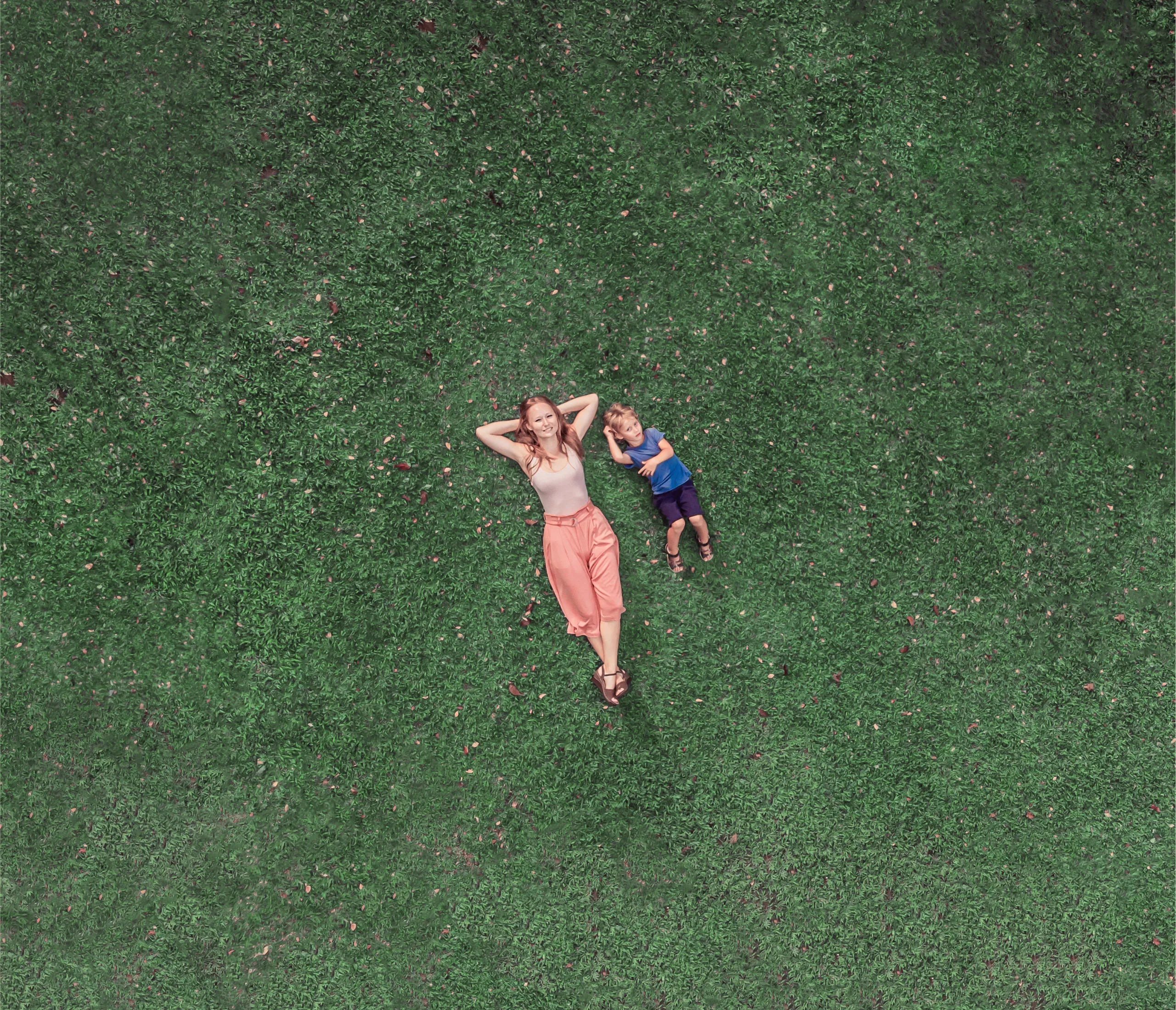 Photo of woman and child lying on the grass